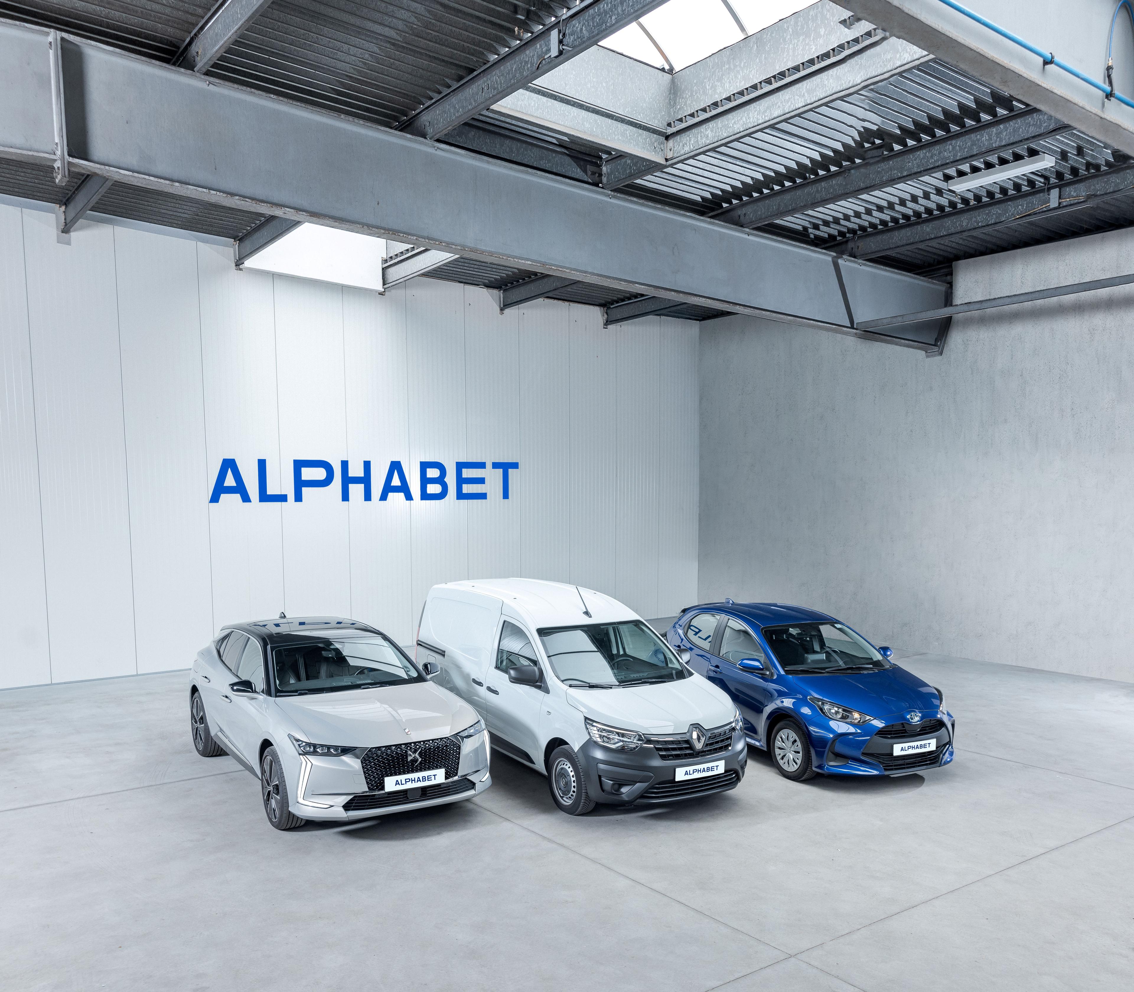 Three vehicles, two cars and a van, lined up against an Alphabet logo backdrop